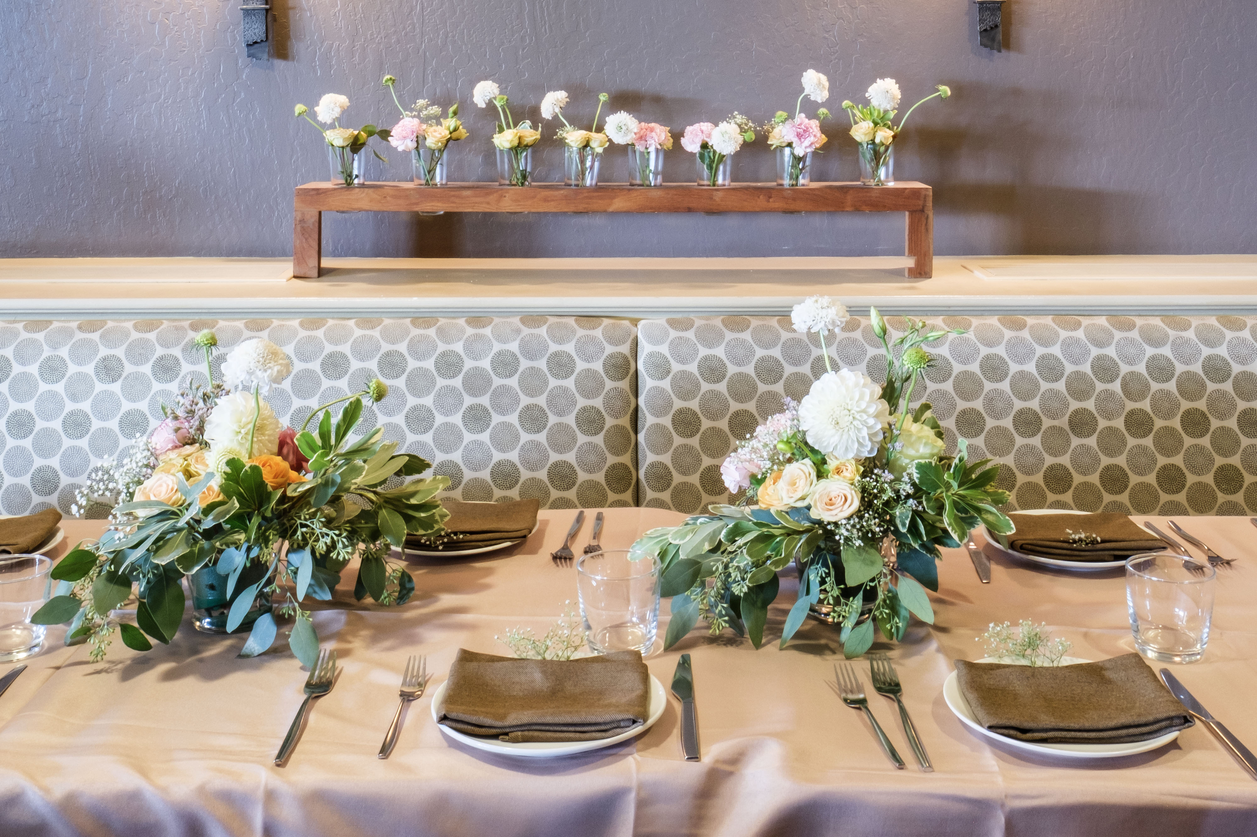 Lounge table setting with floral centerpieces and bud vases